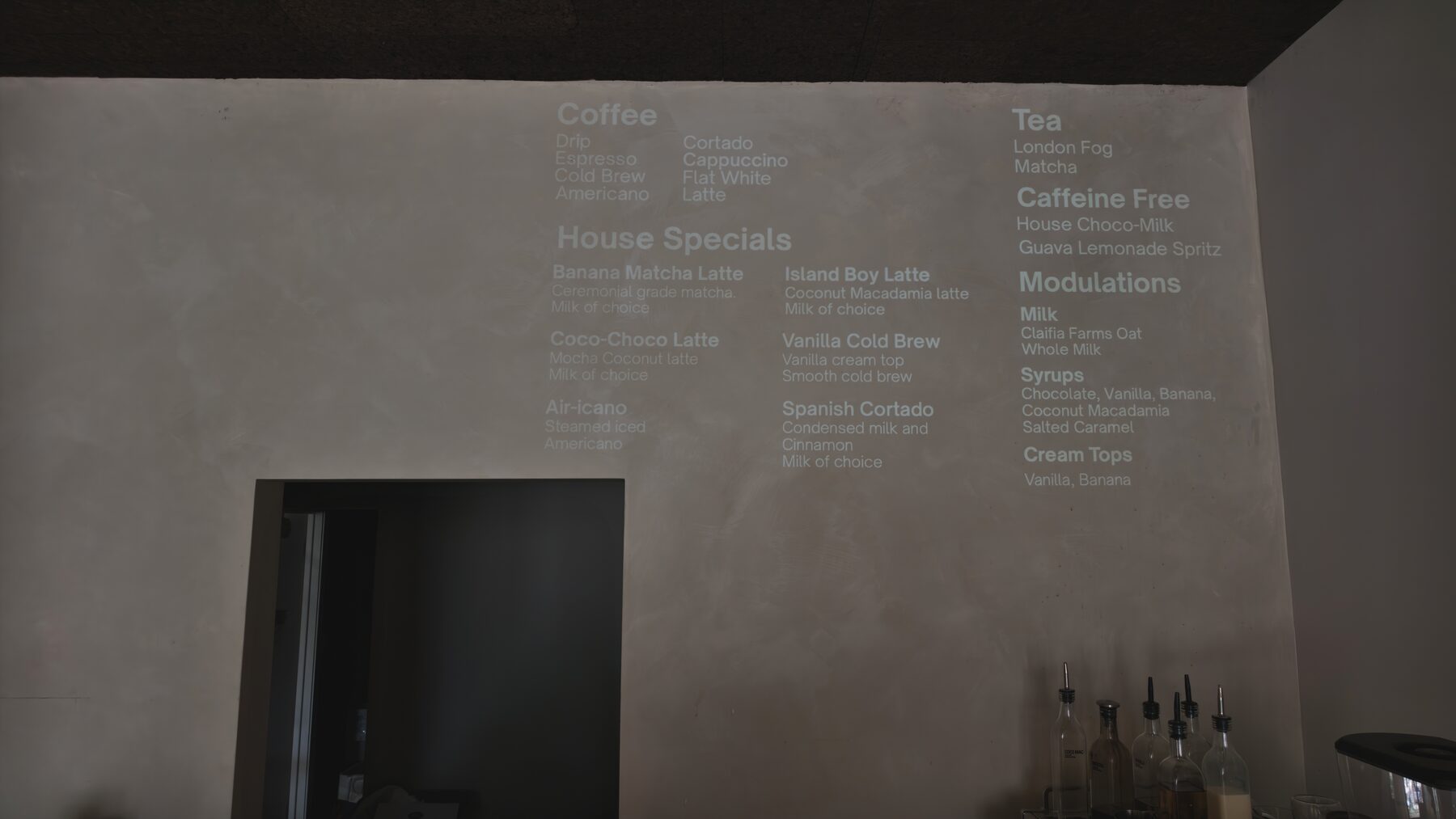 The VESL.HIFI menu projected on the plaster wall above the espresso bar